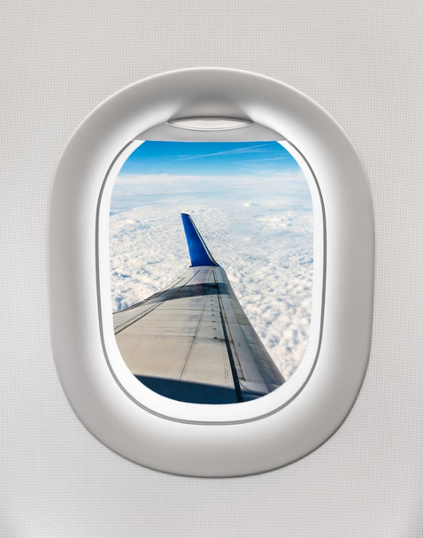 Κοιτώντας έξω από το παράθυρο του αεροπλάνου για το φτερό του αεροσκάφους, σύννεφα - Φωτογραφία, εικόνα