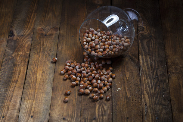 Hazelnuts scattered on a wooden background - Photo, Image