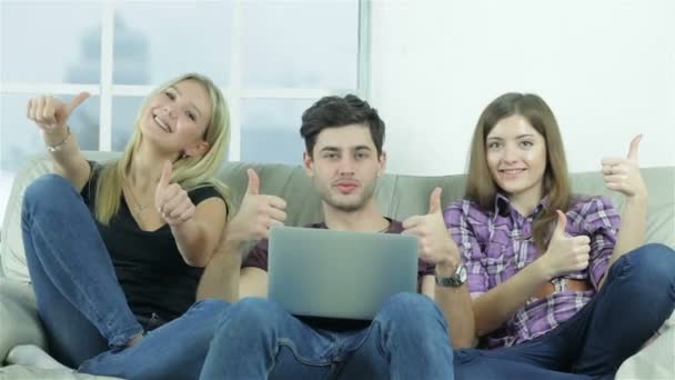 Хлопець і дві дівчини показують пальці зверху прямо в камеру - Кадри, відео