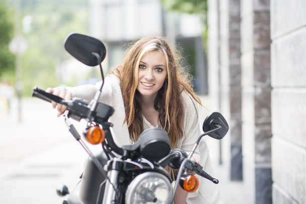 fröhliche Mode junge Frau auf dem klassischen Motorrad auf der Straße. - Foto, Bild