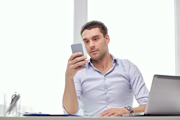 businessman with smartphone and laptop at office - Foto, immagini