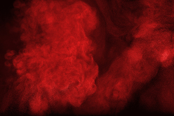 Red powder cloud against dark background - Photo, Image