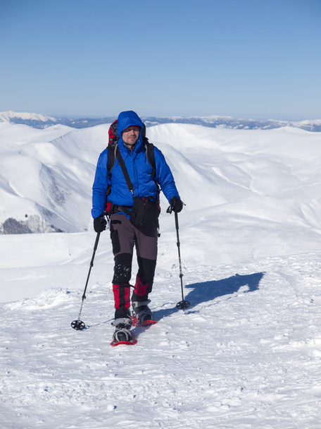 A man with a backpack and snowshoes. - Photo, Image