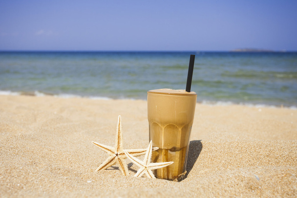 Café gelado em um fundo de praia arenosa
 - Foto, Imagem