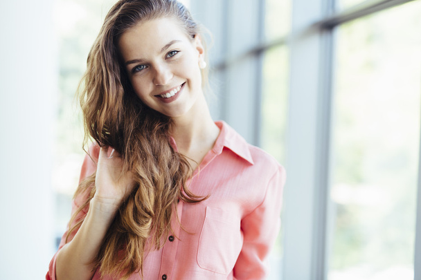 Beautiful businesswoman holding her hair and smiling - Photo, Image