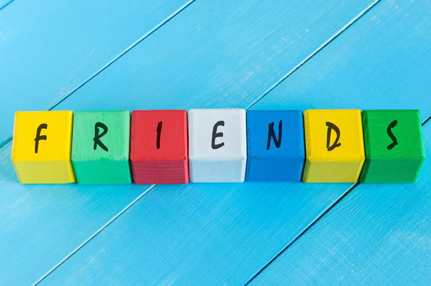 Vrienden - woord over childrens kleurrijke kubussen of blokken. Kleurrijke houten achtergrond - Foto, afbeelding