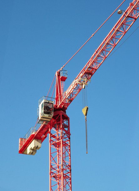 Red industrial construction crane above blue sky background - Photo, image