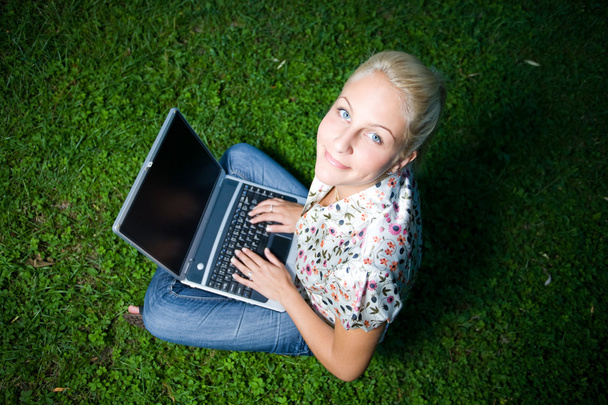 Gorgeous young blond having fun with laptop outdoors - Foto, Imagen
