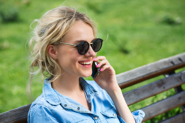 Cute blonde talking on a cell phone. - Foto, afbeelding
