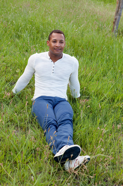 handsome guy sitting on the grass - Zdjęcie, obraz