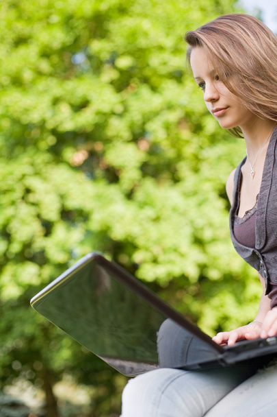 Young student with her laptop outdoors. - Foto, imagen