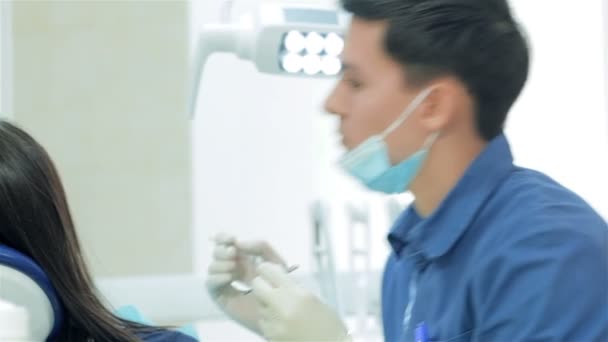 The dentist selects the tool and starts examination of the teeth - Filmmaterial, Video