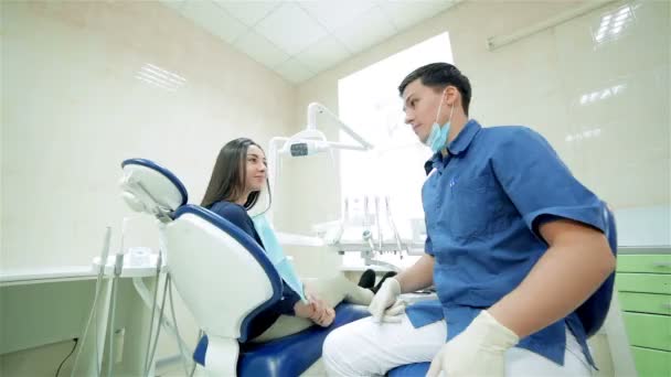 歯科医は、患者に話すし、彼らは一緒に回転させるし、カメラまで親指を表示 - 映像、動画