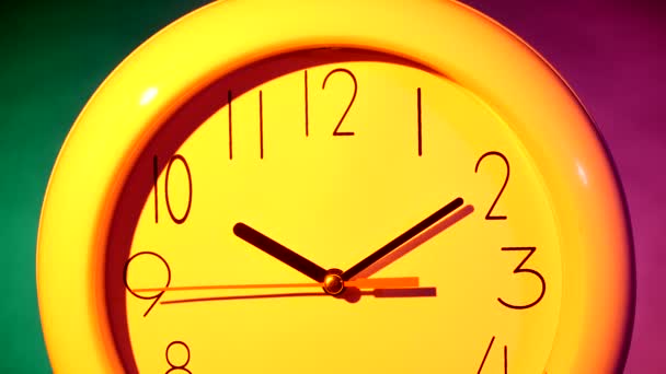 yellow clock on colorful background - Πλάνα, βίντεο