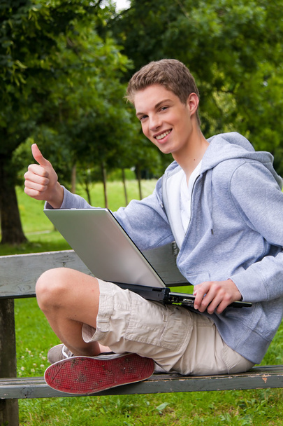 Young man with laptop computer outdoors - Valokuva, kuva