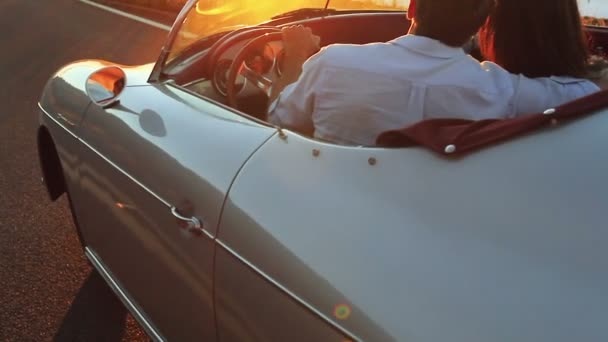Mutlu çift klasik Cabrio araba sürüş gün batımına doğru ülke yolda - Video, Çekim