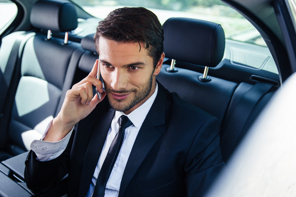 Businessman talking on the phone in car - Фото, зображення