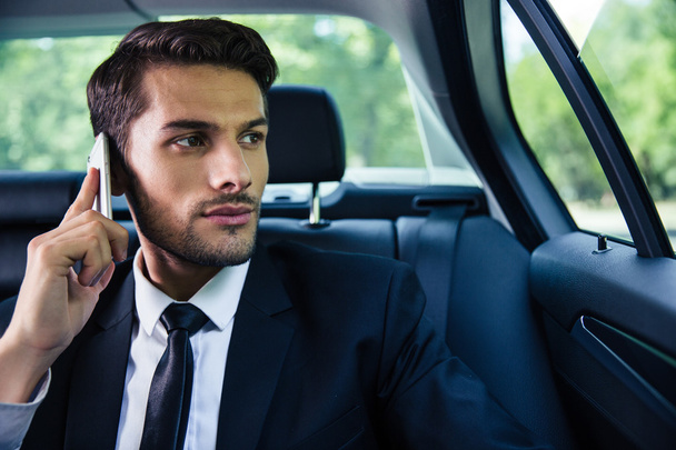 Businessman talking on the phone in car - Фото, зображення