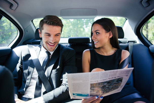 Couple reading newspaper in car - Foto, Imagen