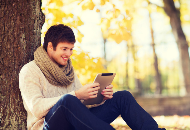 smiling young man with tablet pc in autumn park - Φωτογραφία, εικόνα