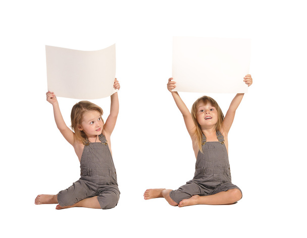 Hermanas gemelas en rompers sosteniendo hojas de papel en blanco aisladas en
 - Foto, Imagen