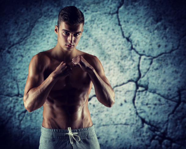 Junger Mann in Kampf- oder Boxposition - Foto, Bild
