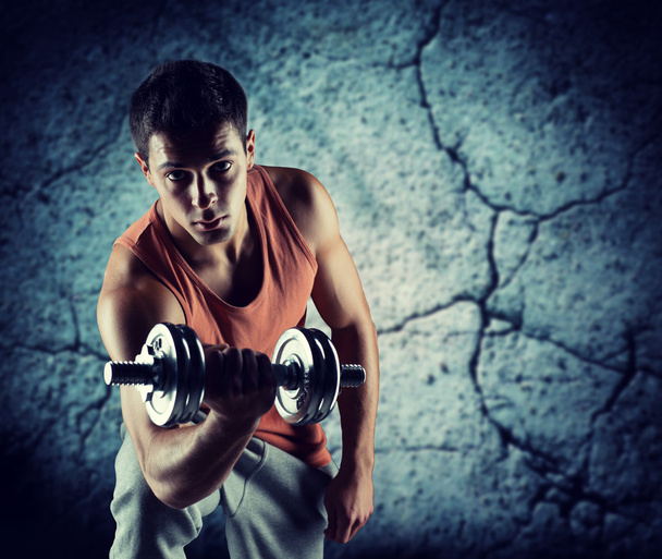 young man with dumbbell flexing biceps - Φωτογραφία, εικόνα