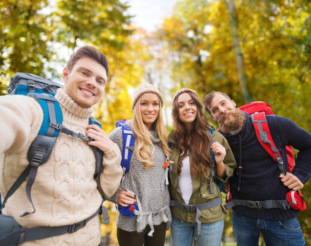 group of smiling friends with backpacks hiking - Foto, Imagen