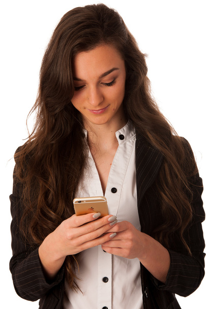 Beautiful young business woman typing a happy note on her smart - 写真・画像