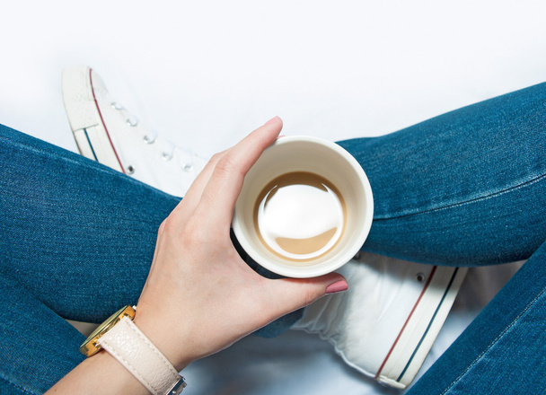 Mulher sentada com xícara de café nas mãos, vista superior
 - Foto, Imagem