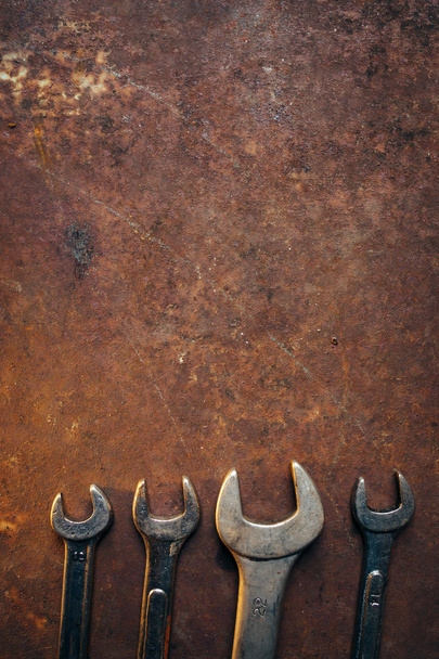 Brilliant wrenches lie on a rusty old metal background - Фото, зображення