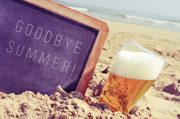 text goodbye summer in a chalkboard and a glass of beer on the b - Photo, Image