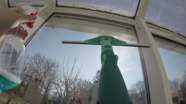 άνθρωπος σπρέι το παράθυρο καθαριστικό, καθαρός με ξύστρα στο εσωτερικό. 4k - Πλάνα, βίντεο