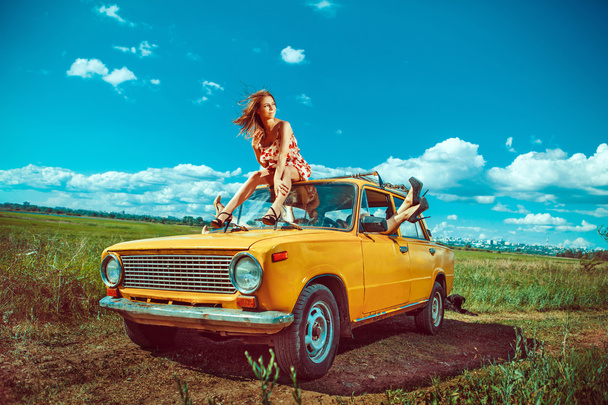 Grupo de hermosas mujeres en el viejo coche amarillo
 - Foto, imagen