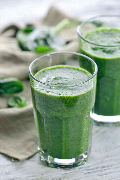 Glasses of spinach juice with napkin on wooden table, closeup - Photo, Image