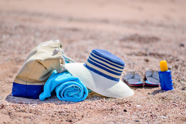Sac de plage et chapeau de soleil sur la plage de sable ensoleillée
 - Photo, image