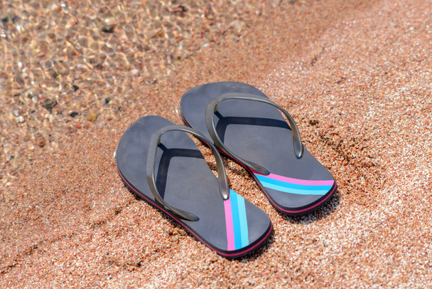 Pair of Flip Flops on Sandy Beach Shore - Fotografie, Obrázek