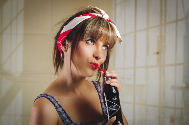 Beautiful retro girl holding an old vintage coca cola bottle - 写真・画像