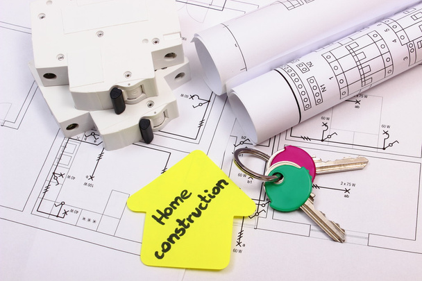Haus aus gelbem Papier, Schlüssel, elektrischer Sicherung und Bauzeichnung - Foto, Bild