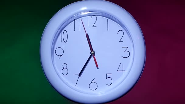 primer plano de un reloj de oficina sobre fondo colorido. cámara lenta
 - Imágenes, Vídeo