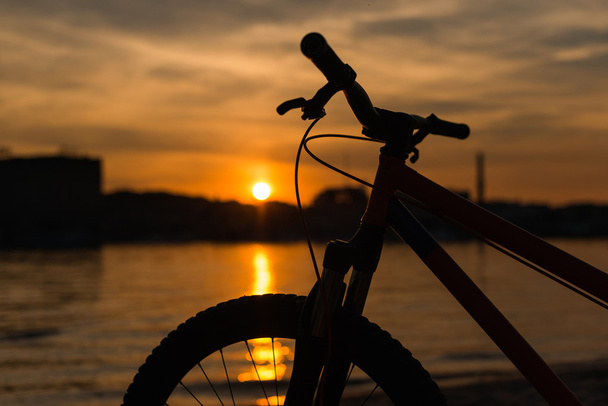 sylwetka roweru na zachód słońca. Krajobraz lato. - Zdjęcie, obraz