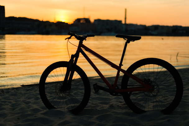 sylwetka roweru na zachód słońca. Krajobraz lato. - Zdjęcie, obraz