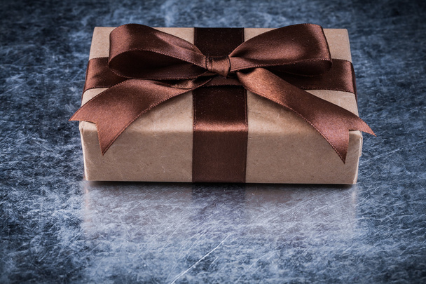 Giftbox with brown ribbon on metallic background - Фото, изображение