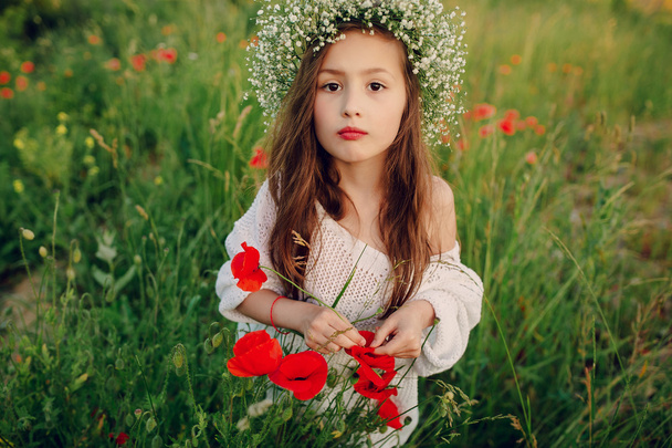 hermosa niña posando en una falda corona de amapolas
 - Foto, imagen
