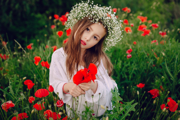 beautiful little girl posing in a skirt wreath of poppies - Фото, изображение