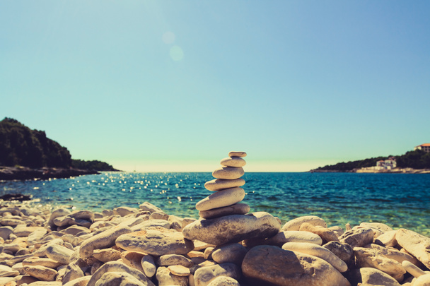 λίθοι ισορροπία, βότσαλα στοίβα πάνω από το γαλάζιο της θάλασσας στην Κροατία. - Φωτογραφία, εικόνα