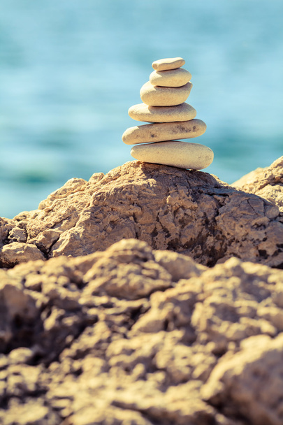 Balanço de pedras na praia, pilha sobre o mar azul
 - Foto, Imagem