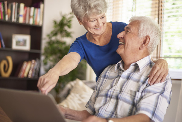 Vanhempi pari käyttää kannettavaa tietokonetta yhdessä
 - Valokuva, kuva