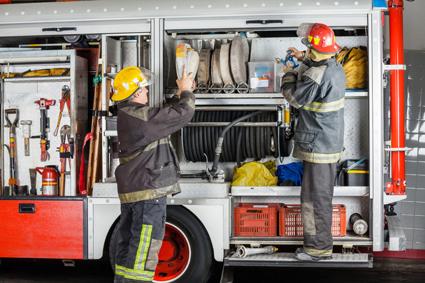Firemen Working At Truck In Fire Station - 写真・画像
