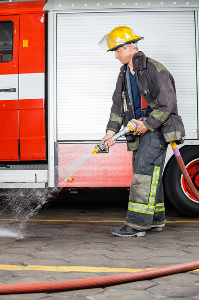 Firefighter Spraying Water On Floor During Training - Valokuva, kuva